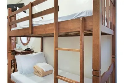 a bunk bed with a ladder towered over a room at Belvilla Airport Stays Near Makati Manila Formerly Avitel Hotel in Manila