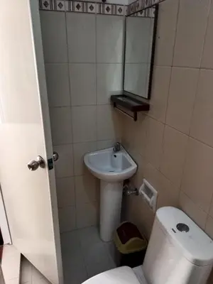 a bathroom with a sink and a toilet and a mirror at Your Little Resort, calm, secure in Manila