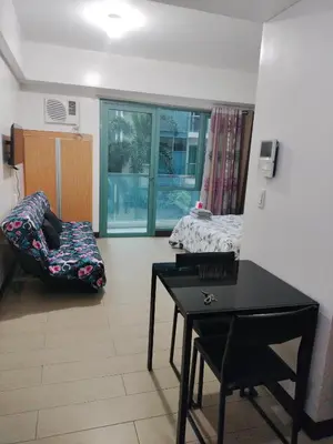 a living room with a table and a chair at Rqui Condotel at Newport Pasay City in Manila