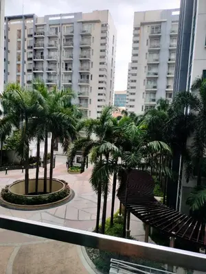 a balcony with palm trees in a city with buildings at Rqui Condotel at Newport Pasay City in Manila