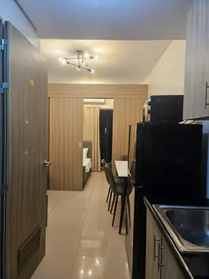 a kitchen with a table and a room with a bedroom at The Executive Suites at Shore 2 Residences in Manila