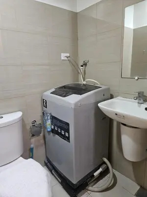 a bathroom with a washing machine and a sink at The Executive Suites at Shore 2 Residences in Manila