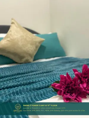 a blue blanket and a pink flower on a bed at Shore 3 Residences Spacious & Spotless 1BR unit near airport MOA SMX in Manila