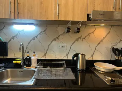 a kitchen sink with a dish drying rack next to it at Modern Sanctuary Near - MOA in Manila