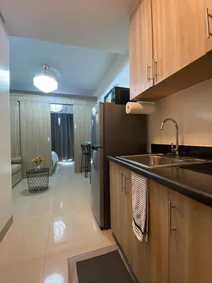 a kitchen with a sink and a refrigerator at Modern Sanctuary Near - MOA in Manila