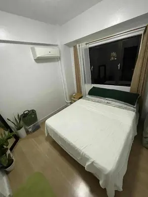 a bedroom with a white bed and a window at BGC Condominium Near St Luke Fort Bonifacio Taguig in Manila