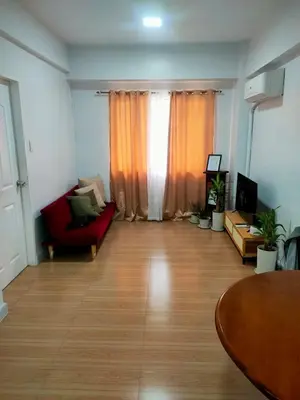 a living room with a red couch and a table at BGC Condominium Near St Luke Fort Bonifacio Taguig in Manila