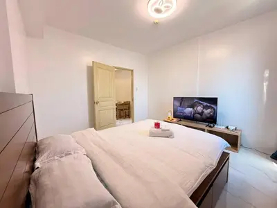 a bedroom with a large bed and a flat screen tv at Manila Korea Town Seaview and City View Staycation in Manila