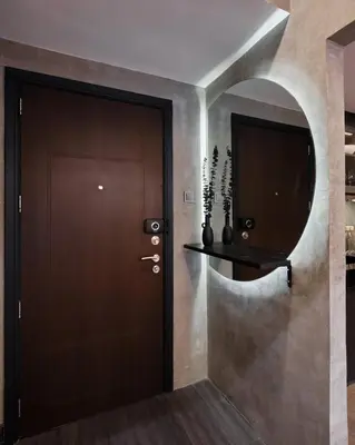 a hallway with a wooden door and a round mirror at Luxury Condo in the heart of BGC in Manila