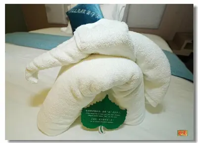 a towel animal made out of toilet paper on a bed at Pristine Hotel in Manila