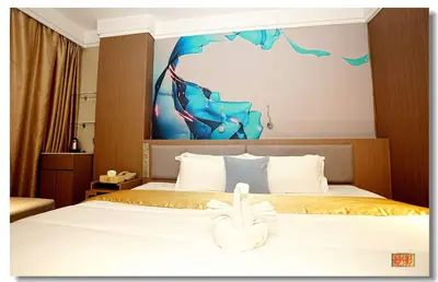 a hotel room with a bed with a towel on it at Pristine Hotel in Manila