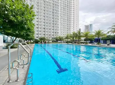 a large swimming pool in front of a large building at Stylish Makati 2BR Condo with KTV and Awesome Pools! in Manila