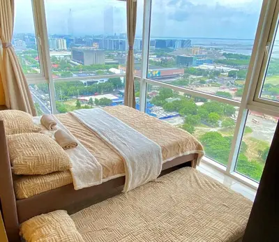 a bed in a room with a large window at SMDC BREEZE RESIDENCES Pasay near AIRPORT PICC CCP WORLD TRADE CENTER MOA AND STARCITY in Manila