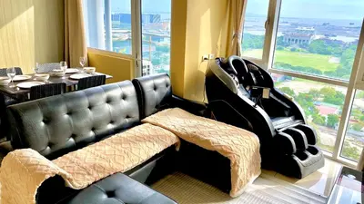a living room with a leather couch and a table at SMDC BREEZE RESIDENCES Pasay near AIRPORT PICC CCP WORLD TRADE CENTER MOA AND STARCITY in Manila