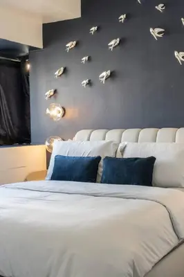 a bedroom with a large bed with birds on the wall at BGC Designer Pad Near Shops Dining Nightlife in Manila
