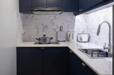 a kitchen with blue cabinets and a pot on the stove at BGC Designer Pad Near Shops Dining Nightlife in Manila