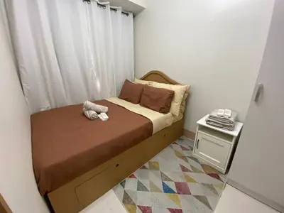 a small bedroom with a bed with a stuffed animal on it at The Residence Suite in Manila