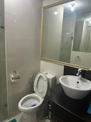 a bathroom with a toilet and a sink and a mirror at Relax Here! STUDIO TYPE in Manila