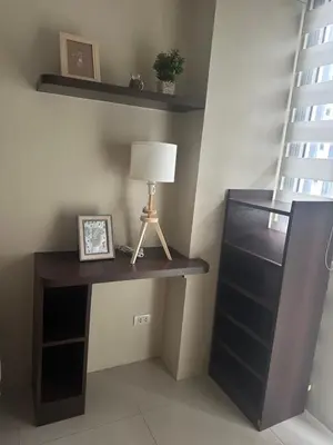 a desk with a lamp on it next to a shelf at Relax Here! STUDIO TYPE in Manila