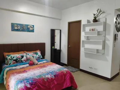 a bedroom with a bed with a teddy bear on it at LDN Two Palm Tree Newport Home in Manila