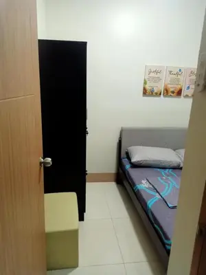 a small bedroom with a bed and a black door at Len's Den 3 Entire Flat in Mall of Asia Pasay Manila in Manila