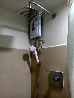 a bathroom with a hair dryer on the wall at Len's Den 3 Entire Flat in Mall of Asia Pasay Manila in Manila