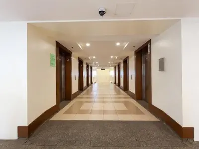 an empty hallway of a building with doors and a hallwayngth at Family-Ready Skyline Retreat near BGC with Free Parking in Manila