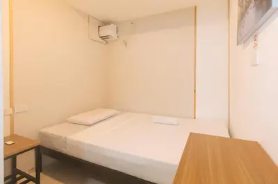 a small room with a bed and a table at Maine Residences Tramo near NAIA Terminal in Manila