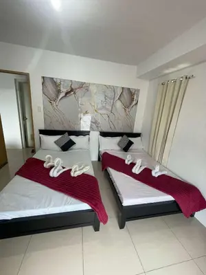 a bedroom with two beds with white towels on them at 1158-2Br 6beds 2 extra mattress 2-sofa in Manila