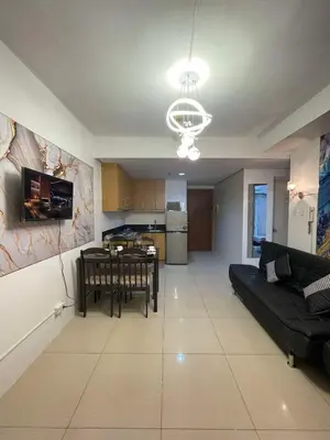 a living room with a black couch and a table at 1158-2Br 6beds 2 extra mattress 2-sofa in Manila