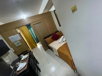 a small room with a bed and a bathroom at 1br big cut 1524D Window Edsa Moa 2beds Queen size 1pullout 1extra mattress in Manila