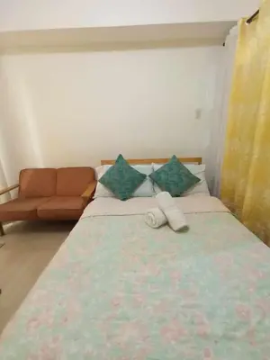 a bedroom with a large bed with a couch at azure beach front view in Manila