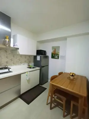 a kitchen with a wooden table and a kitchen with a table and a dining room at azure beach front view in Manila