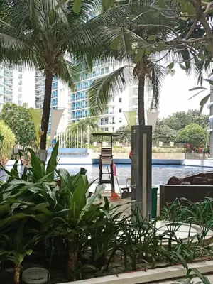 a playground in the middle of a building with palm trees at azure beach front view in Manila