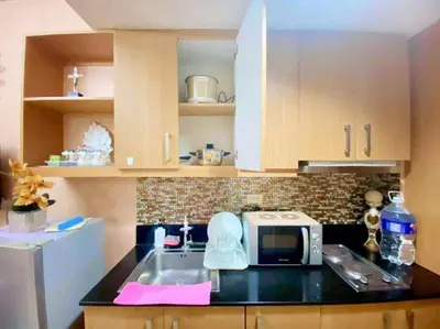 a kitchen with a sink and a microwave on a counter at 1528-1br-1bed-1sofa bed 1pull out pool view with balcony in Manila