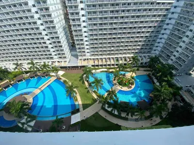 an overhead view of two large buildings with pools and palm trees at 1046-2Br 2bed 1extra matress pool view with balcony in Manila