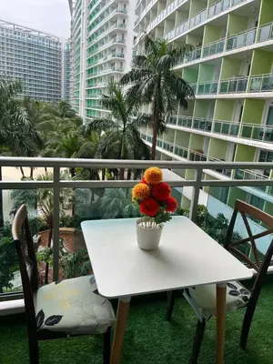 a white table with a vase of flowers on a balcony at 1 bedroom azure beachview 6 in Manila