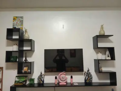 a room with a tv on a wall with shelves at 241-1br -1bed 1 extra mattress in Manila