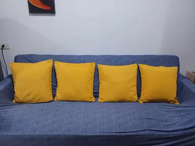 a blue couch with four yellow pillows on it at 241-1br -1bed 1 extra mattress in Manila