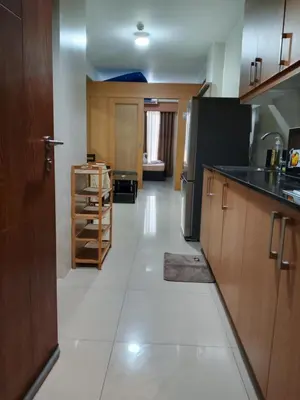 a kitchen with wooden cabinets and a black refrigerator at 349-1br 1bed quenn 1sofa bed 2extra mattress moa view with balcony in Manila