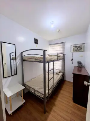 a bedroom with two bunk beds and a mirror at Ysabella's Abode in Manila