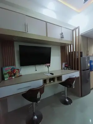 a kitchen with a desk with a tv and two chairs at Cozy Couple Room near mall of asia in Manila