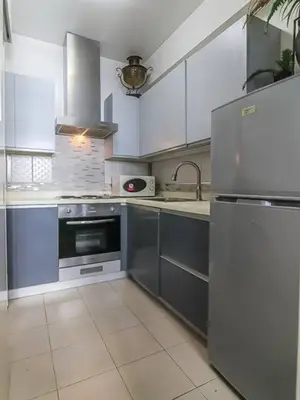 a kitchen with white cabinets and a stainless steel refrigerator at BGC Urban Studio Prime Spot, Walk to Everything in Manila