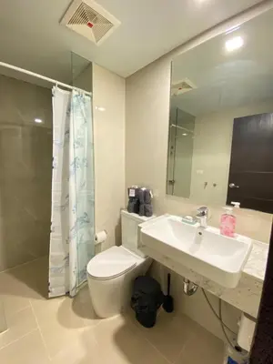 a bathroom with a sink and a toilet and a mirror at A1 Suite in McKinley in Manila