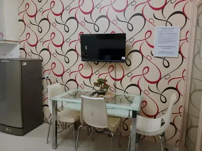 a table with chairs and a tv on a wall at Sea Residence Tower by let's Bareds in Manila