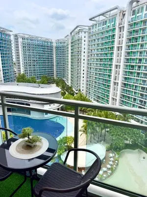 a balcony with a table and chairs and buildings at SM Bicutan Condotels by Sibs in Manila