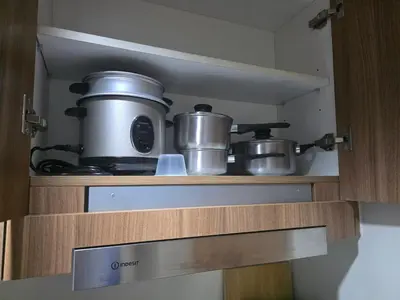 a kitchen with pots and pans on a shelf at Aloha Escape for Coffee Lovers in Manila