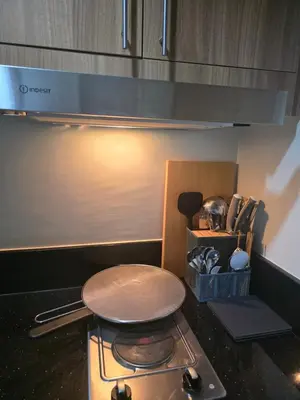 a kitchen with a stove with a stool on it at Aloha Escape for Coffee Lovers in Manila