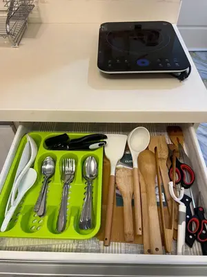 a drawer with a green tray filled with utensils at AZURE STAYCATION by TALA in Manila
