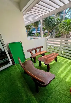 a patio with two benches and a greenboard on the grass at AZURE STAYCATION by TALA in Manila